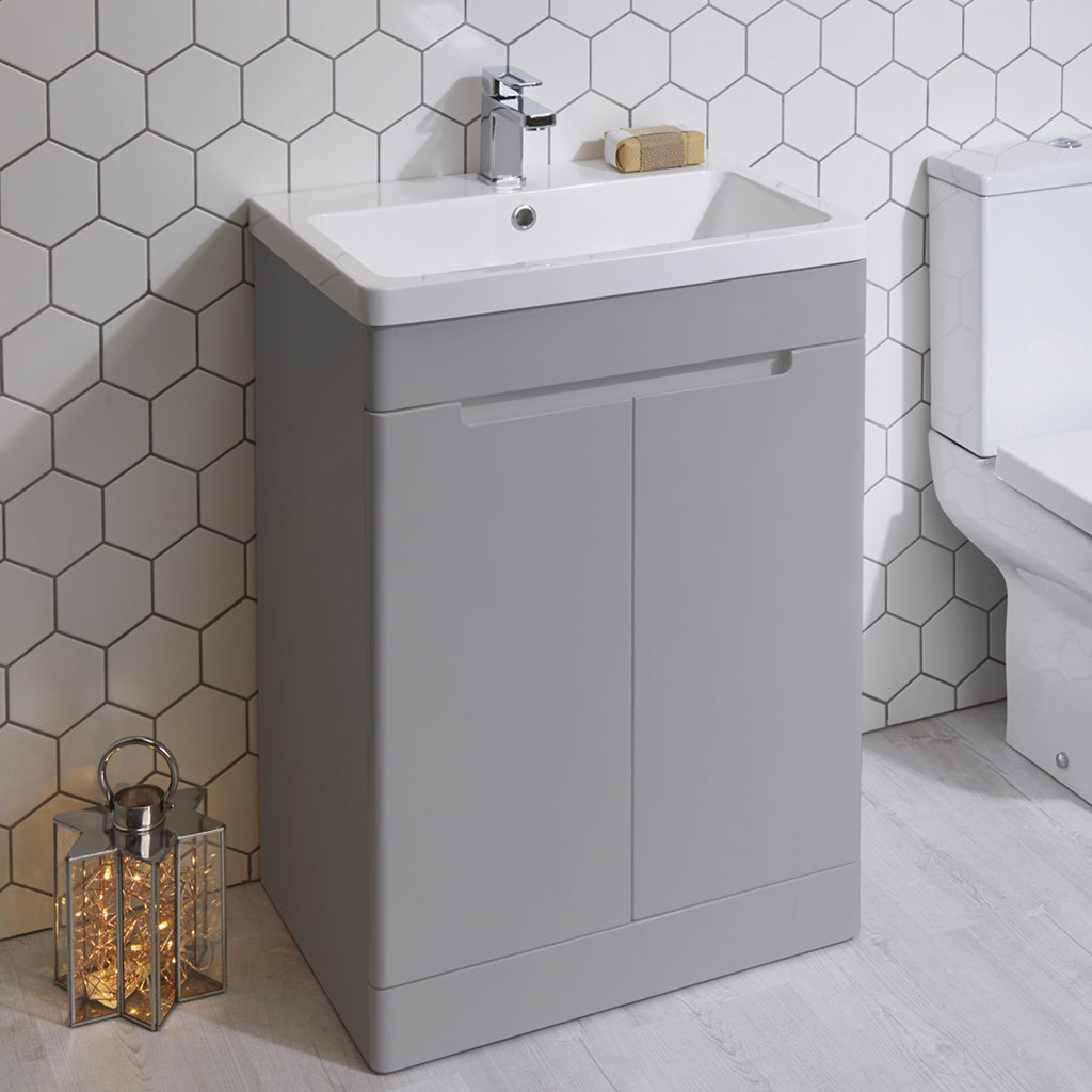 Modern grey bathroom vanity unit with sink and chrome tap, set against hexagon tile wall