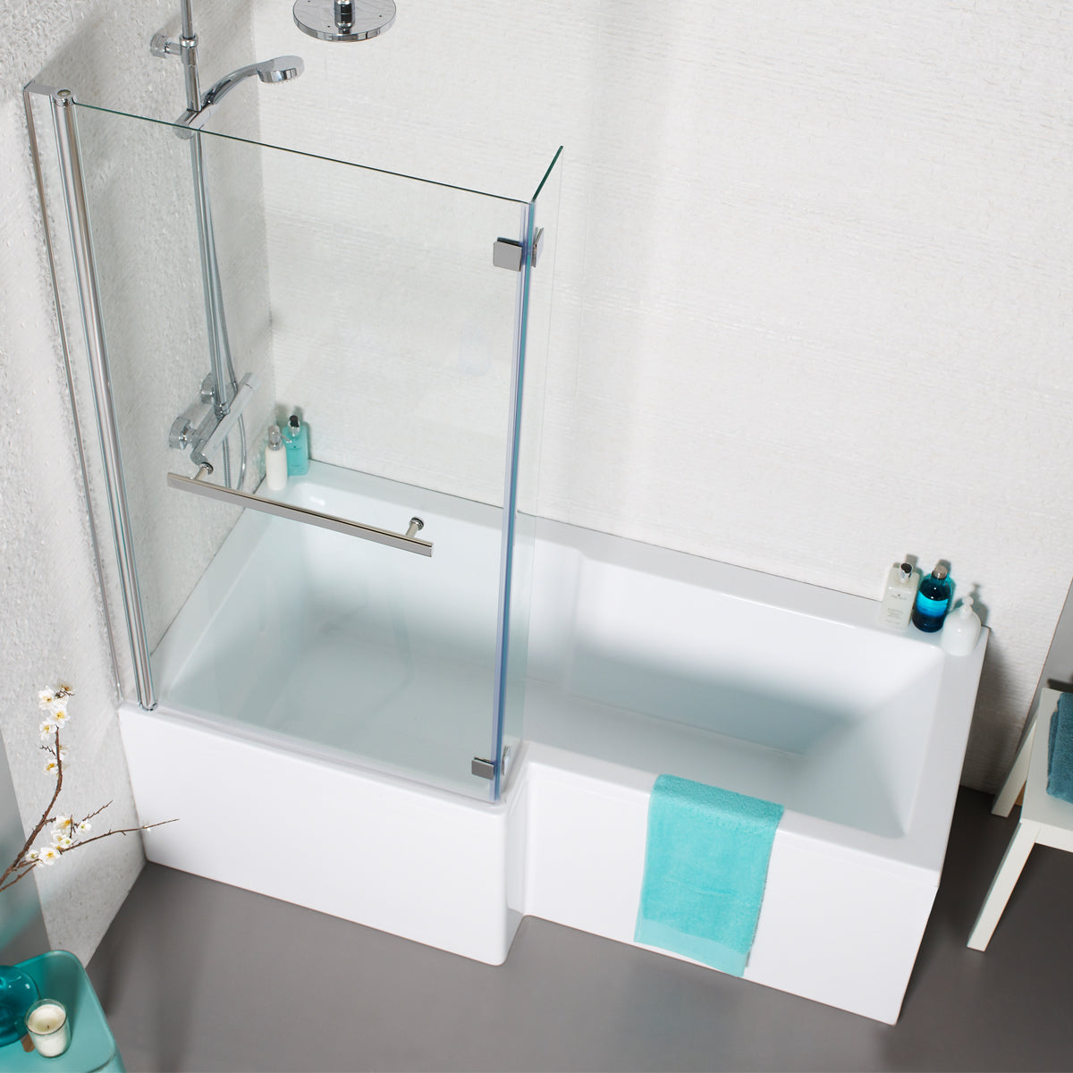 Modern L-shaped shower bath with glass screen, chrome shower, and turquoise towel