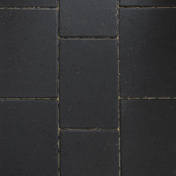 Dark grey concrete paving blocks arranged in a rectangular pattern for landscaping or driveways