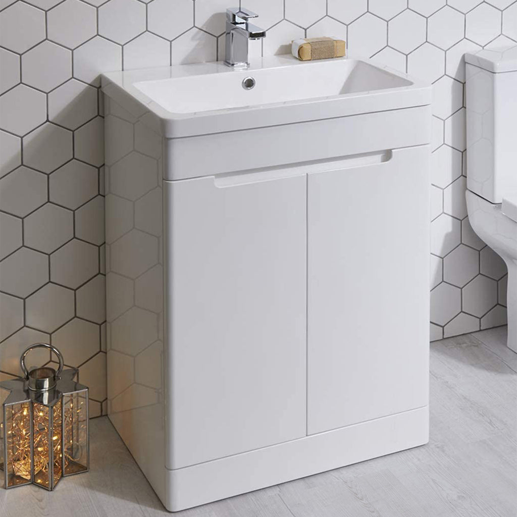 Modern white bathroom vanity unit with basin and chrome tap against hexagon tile wall