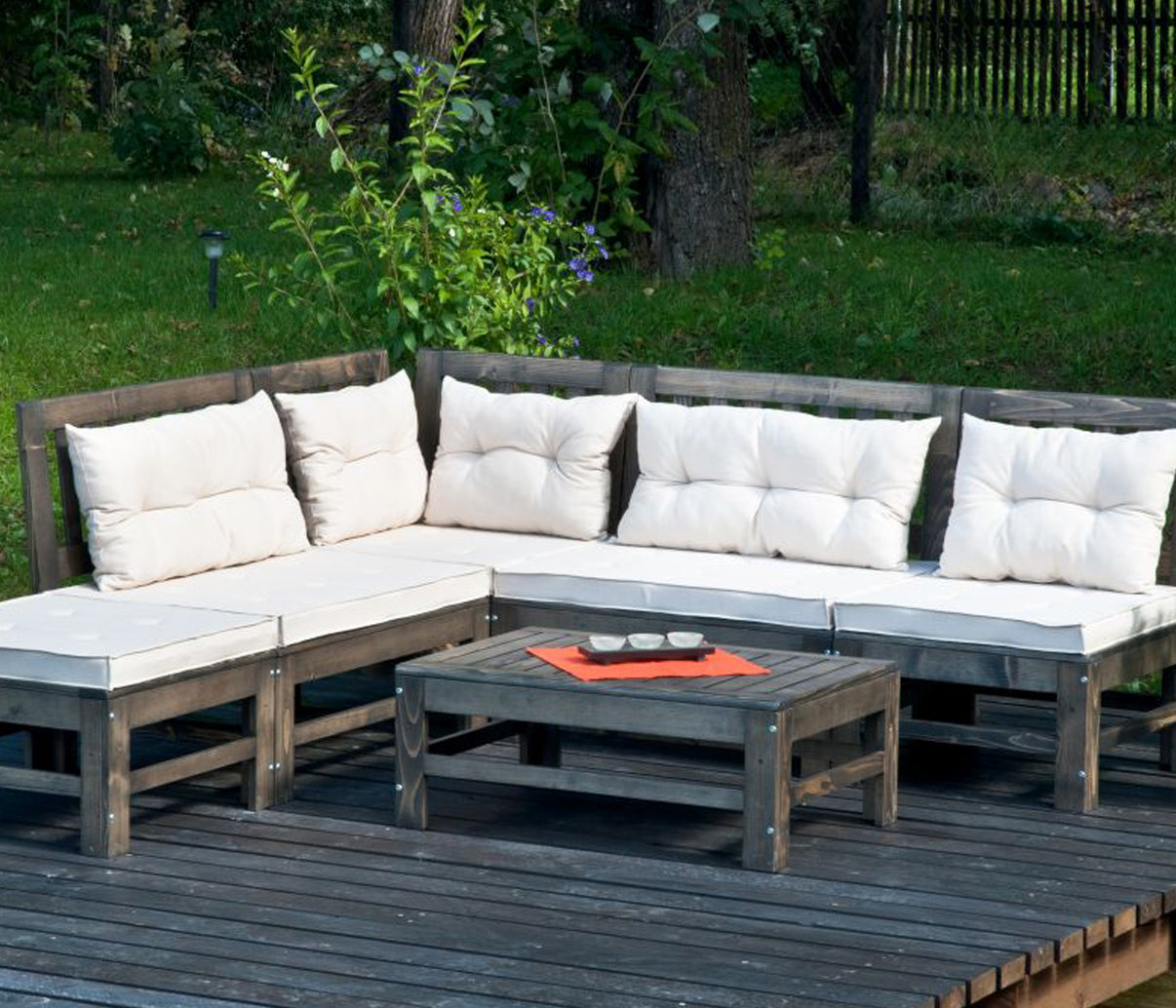 Outdoor wooden garden furniture set with beige cushions on a decked patio