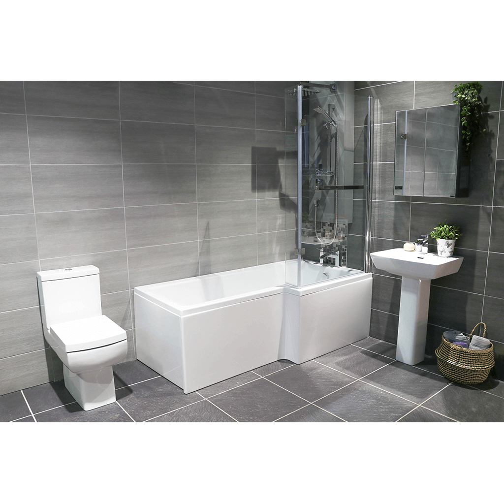 Modern bathroom suite with grey tiles, L-shaped bath, toilet, pedestal sink, and glass shower screen