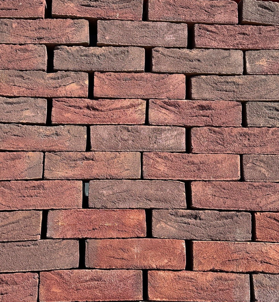 Red clay bricks stacked for building supplies, textured brick wall surface